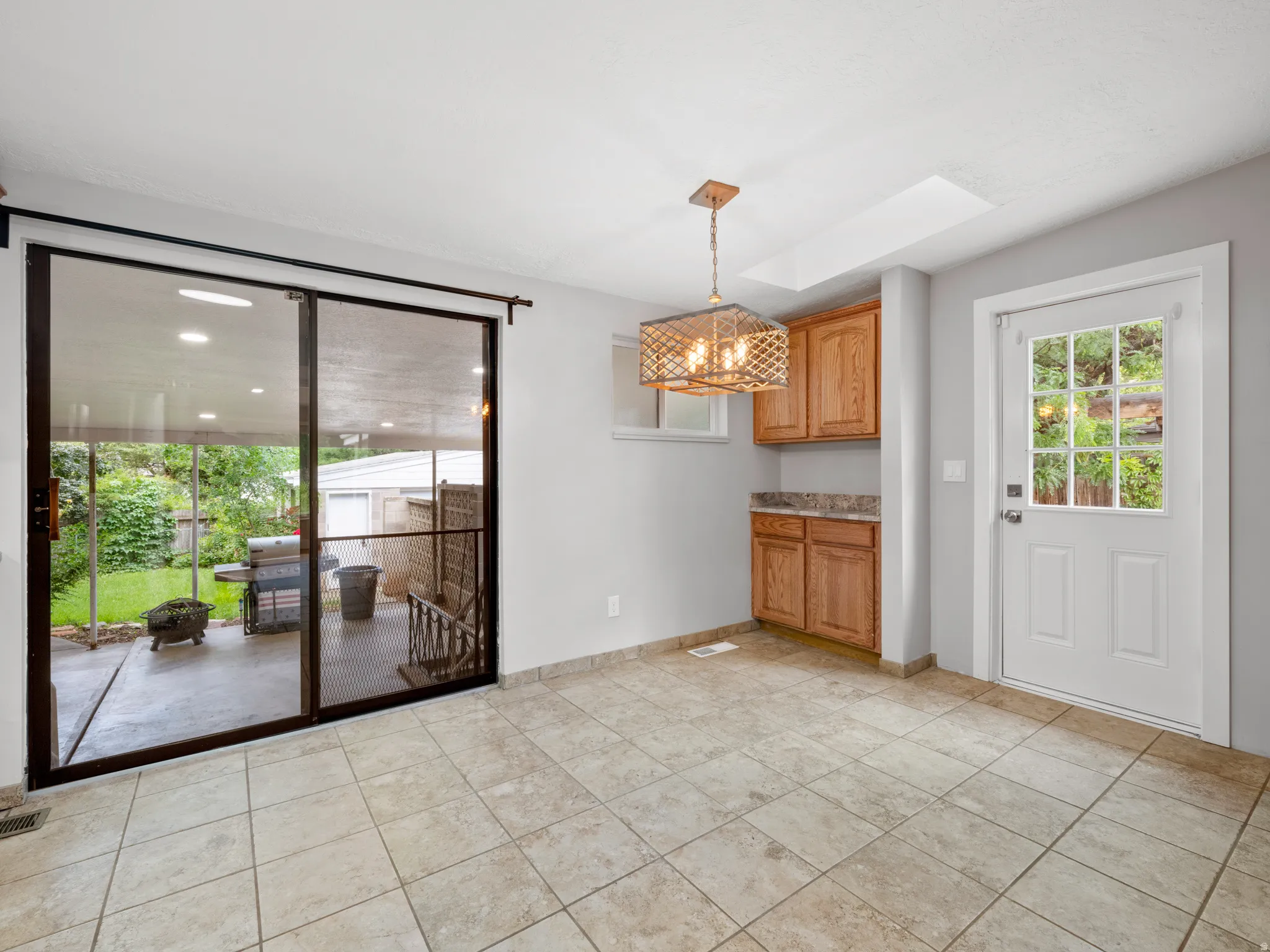Unfurnished dining area with suspended lighting and a skylight