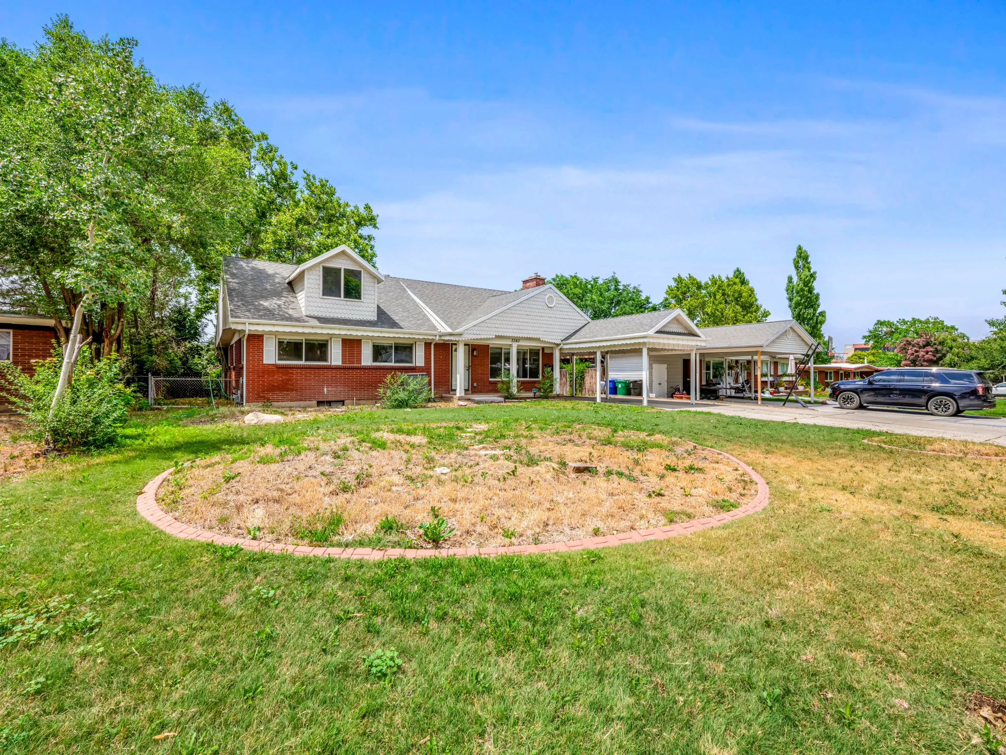 View of front facade featuring brick siding, concrete driveway, covered porch, a garage, and a shingled roof