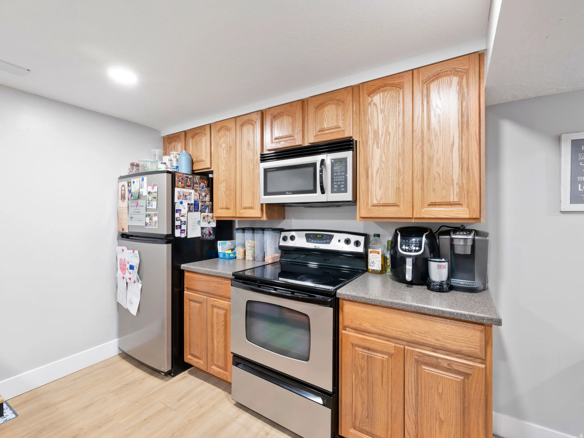 Kitchen featuring stainless steel appliances, light wood-style flooring, and light countertops