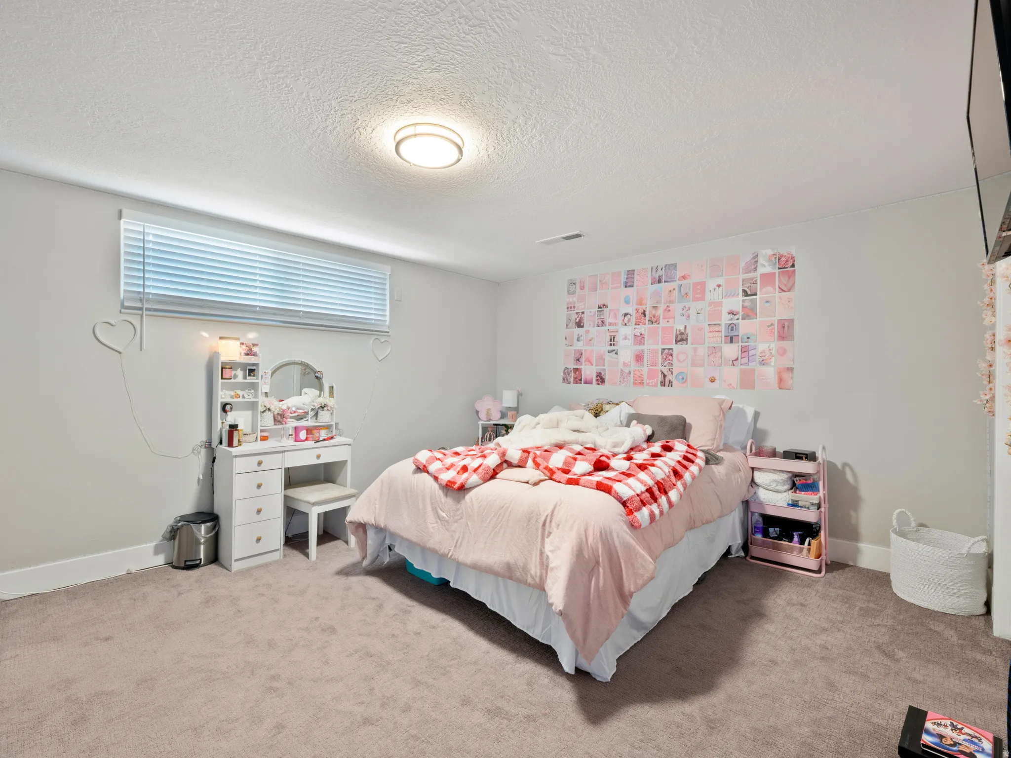 Bedroom with light colored carpet and a textured ceiling