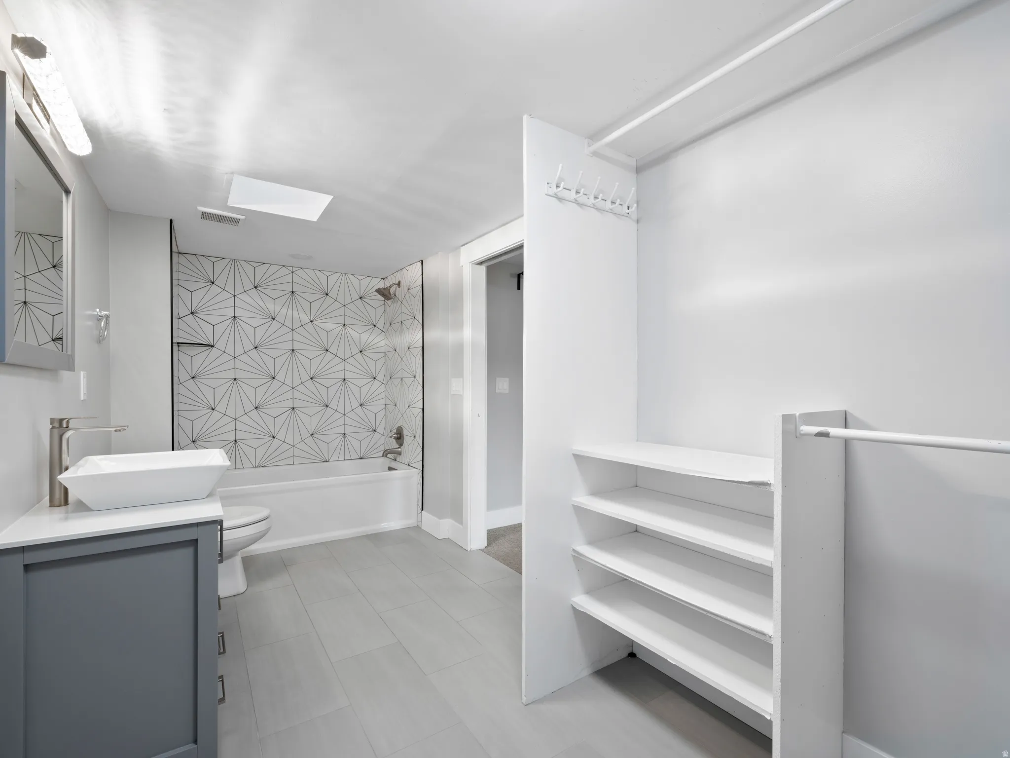 Bathroom featuring washtub / shower combination and vanity