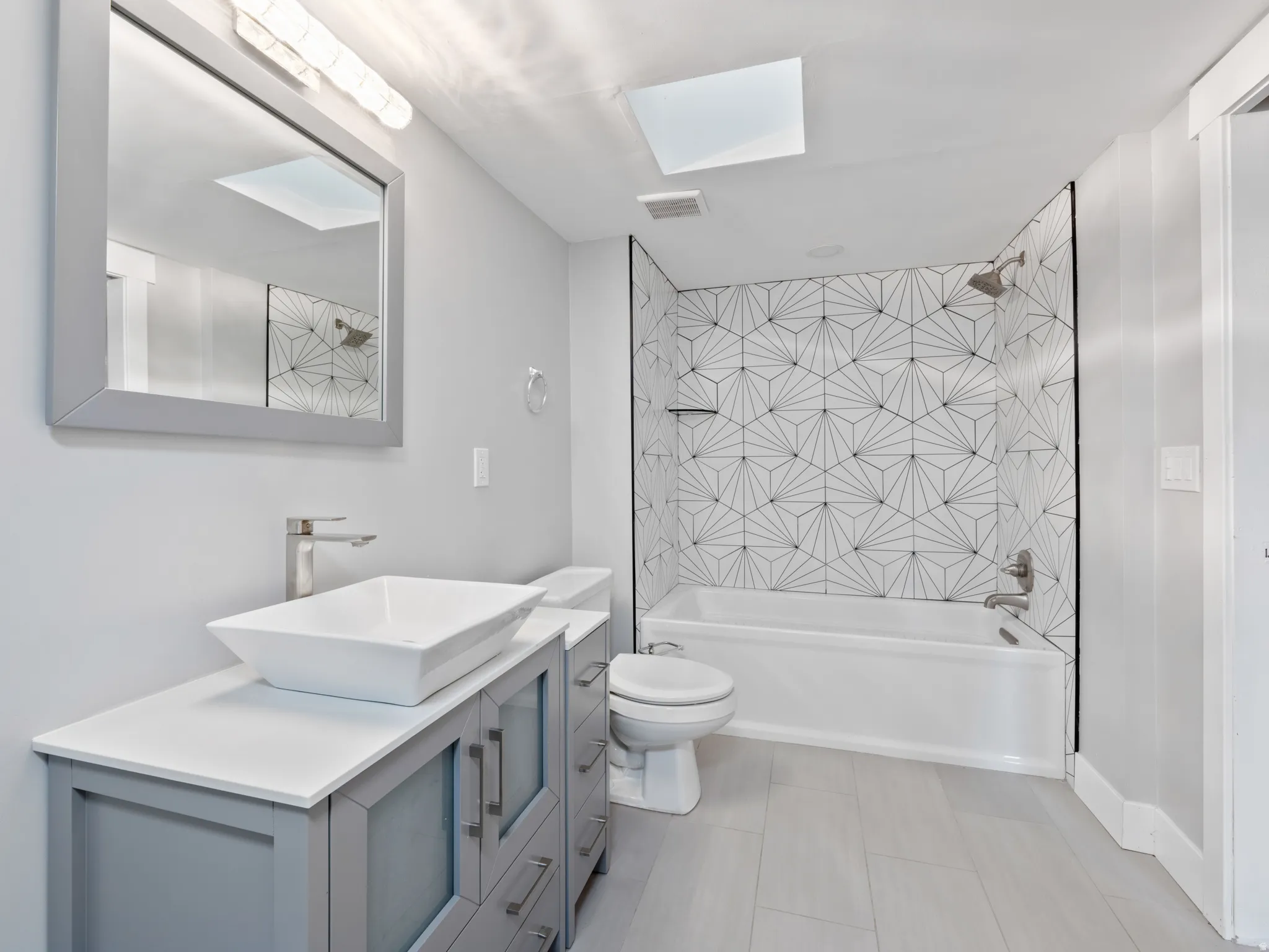 Full bath with vanity,  shower combination, and a skylight
