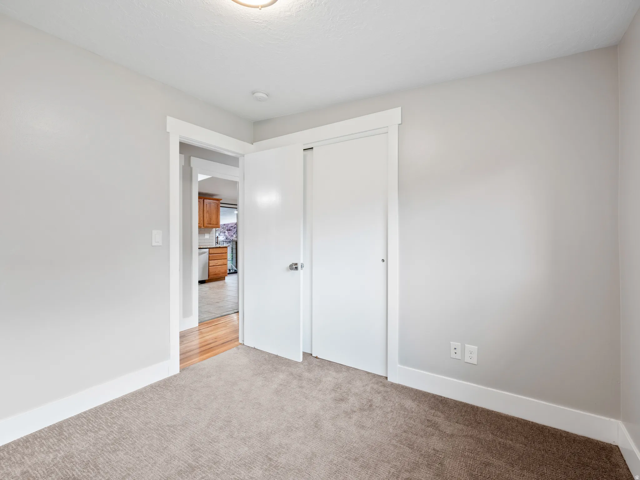 Unfurnished bedroom with light colored carpet and a closet