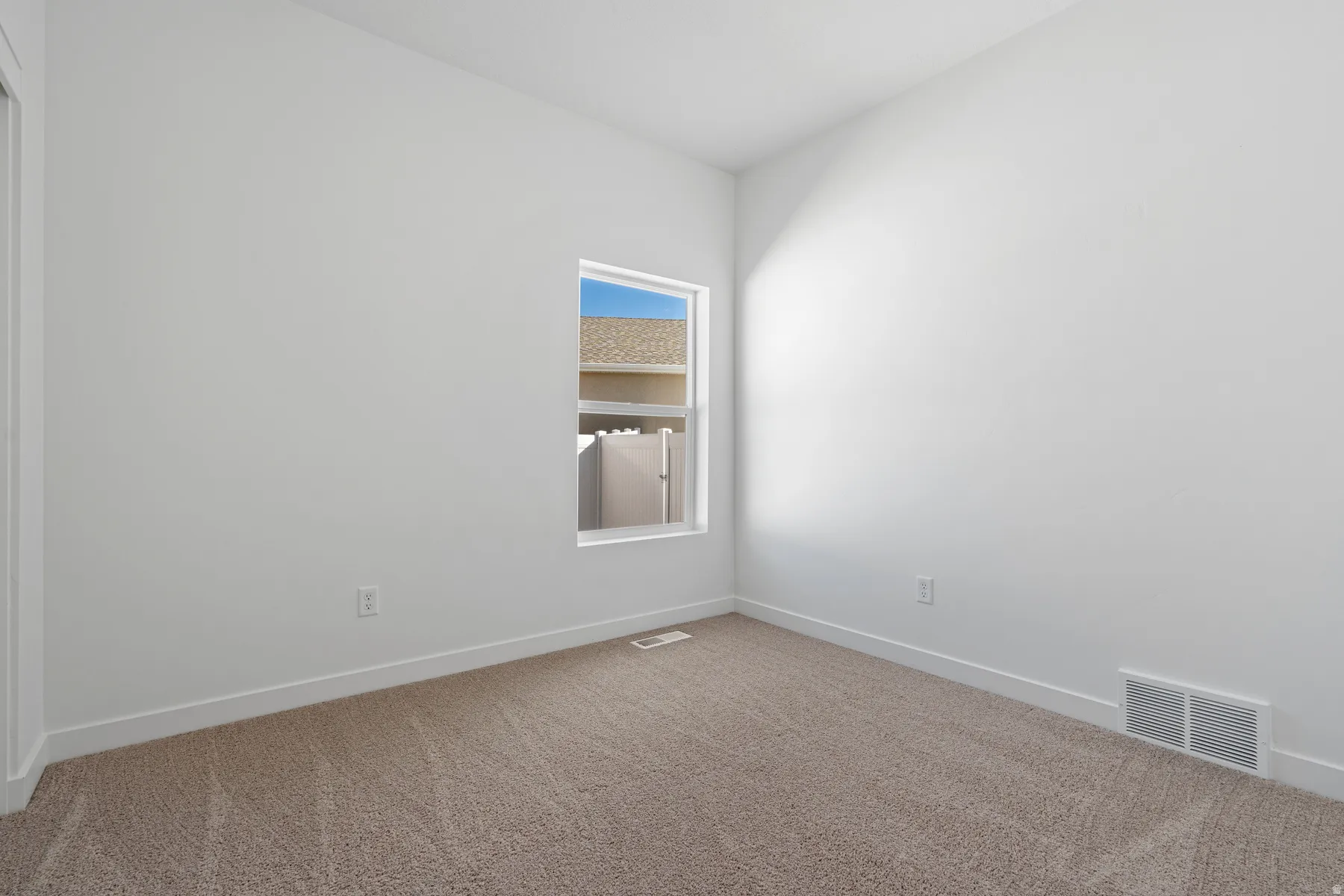 Carpeted empty room with baseboards