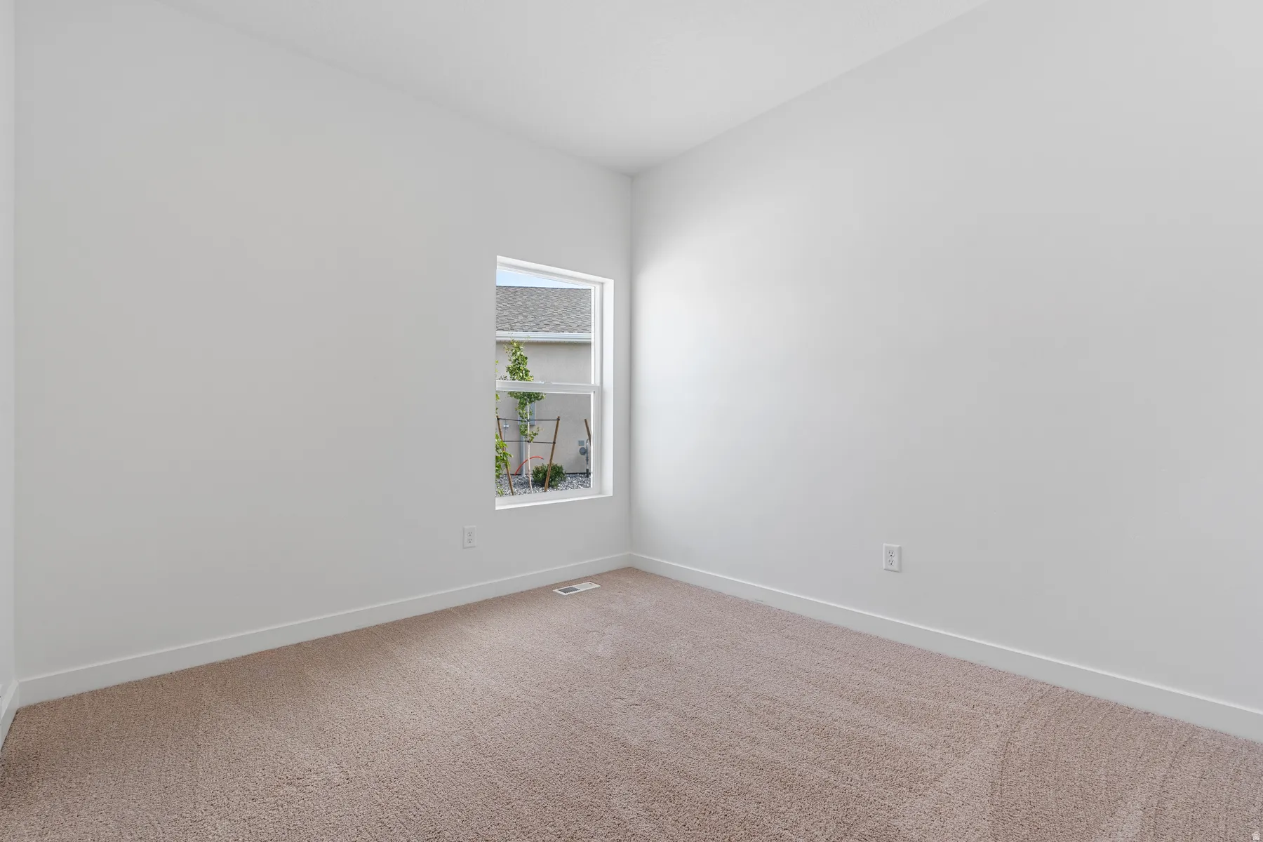 Carpeted empty room with baseboards