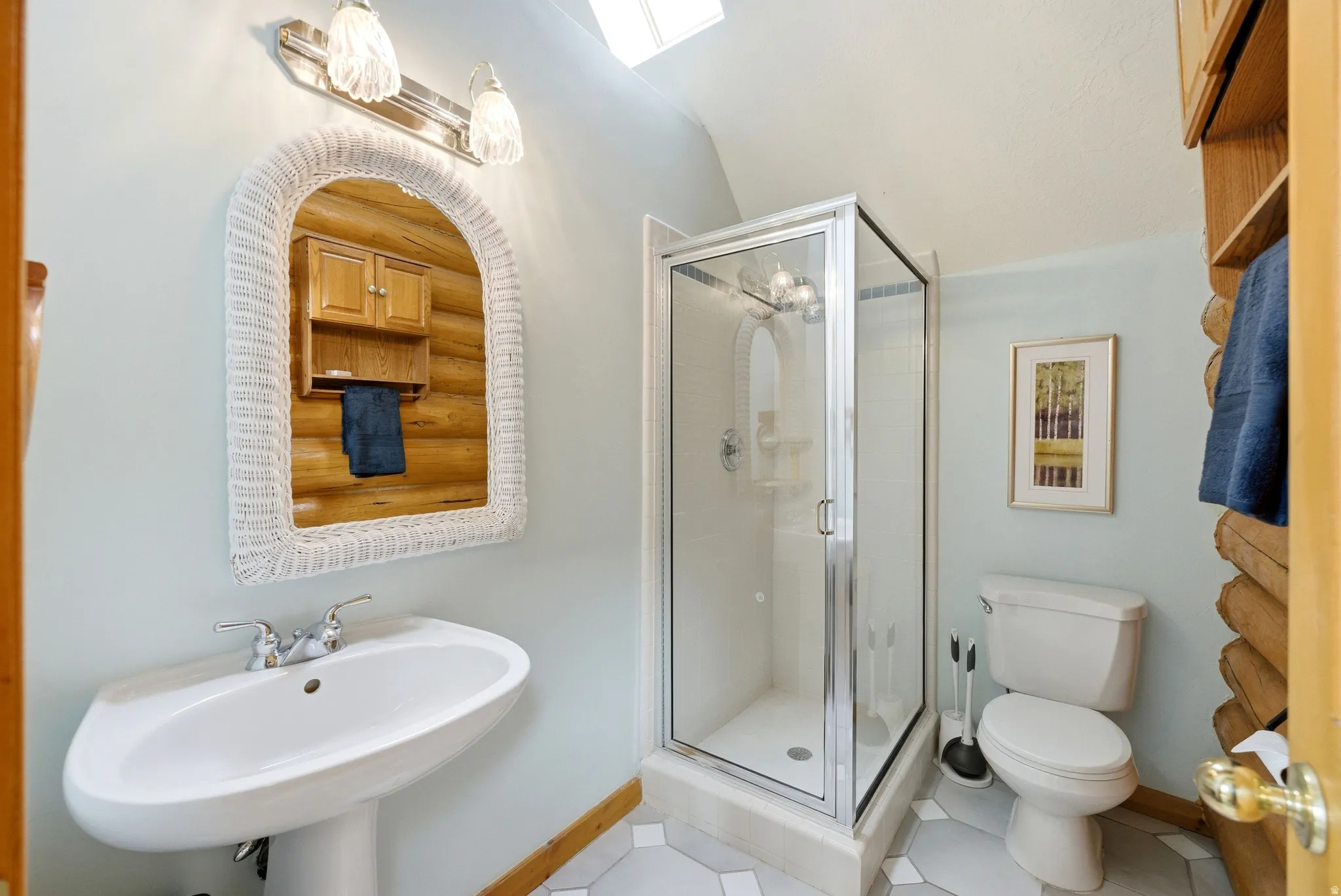 Full bath with a shower stall and lofted ceiling