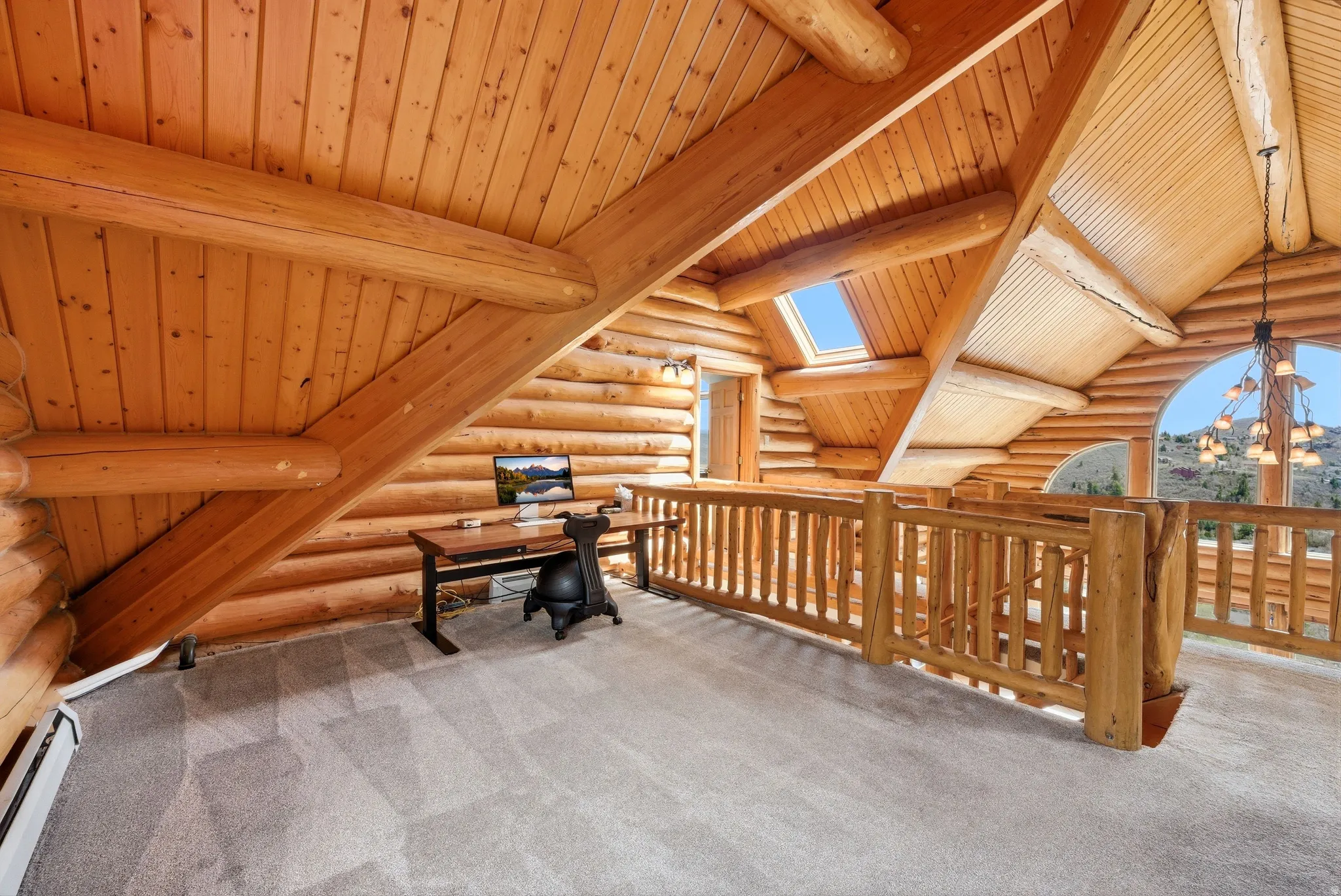 Unfurnished office featuring rustic walls, carpet flooring, a skylight, a baseboard heating unit, and wood ceiling