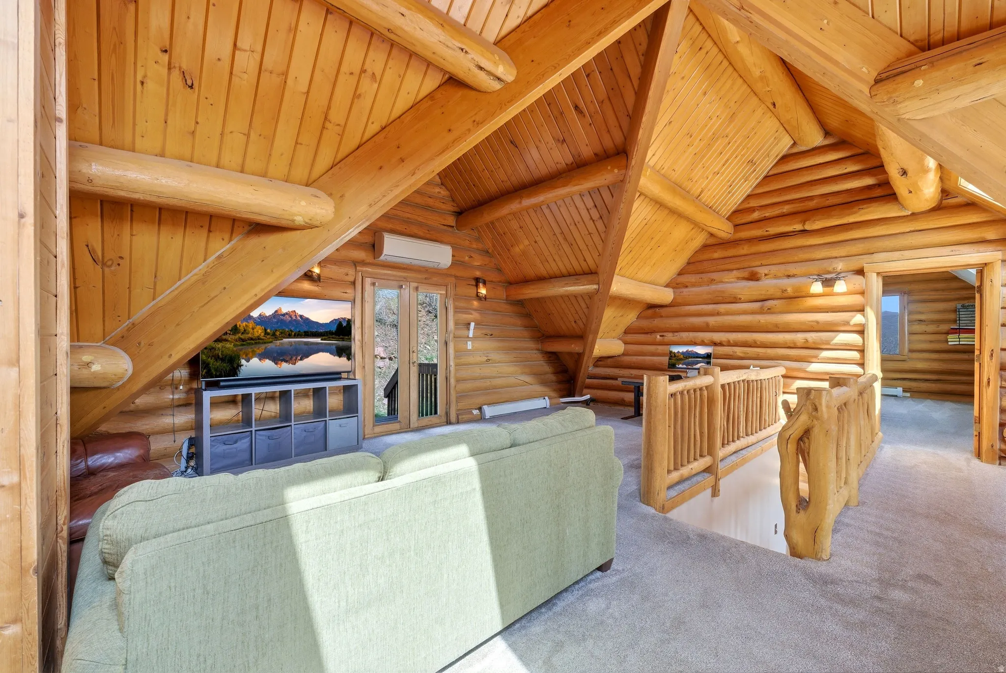 Living area featuring log walls, carpet flooring, wooden ceiling, and lofted ceiling with beams