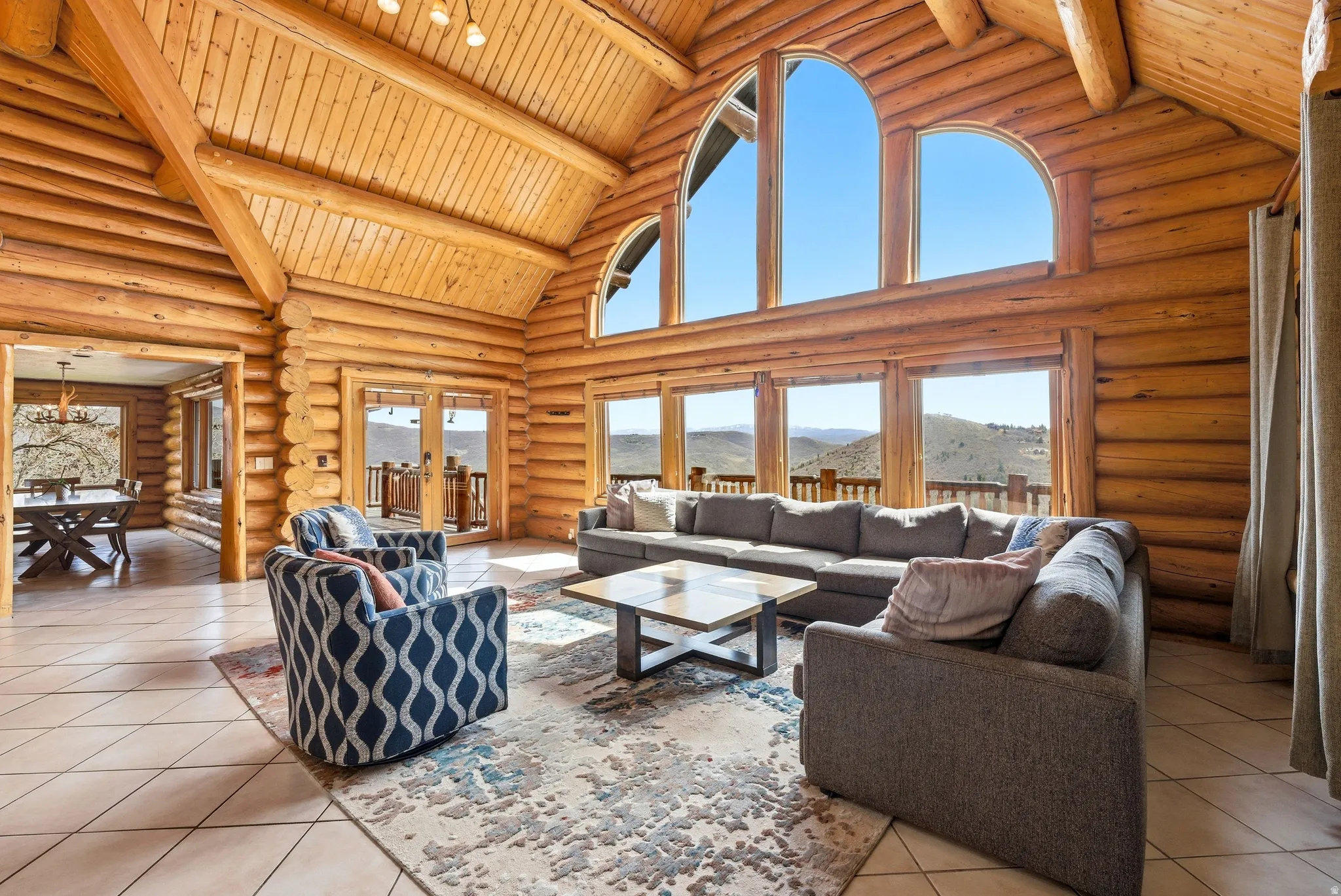 Living area featuring a mountain view, a high wood beamed ceiling, log walls, and french doors