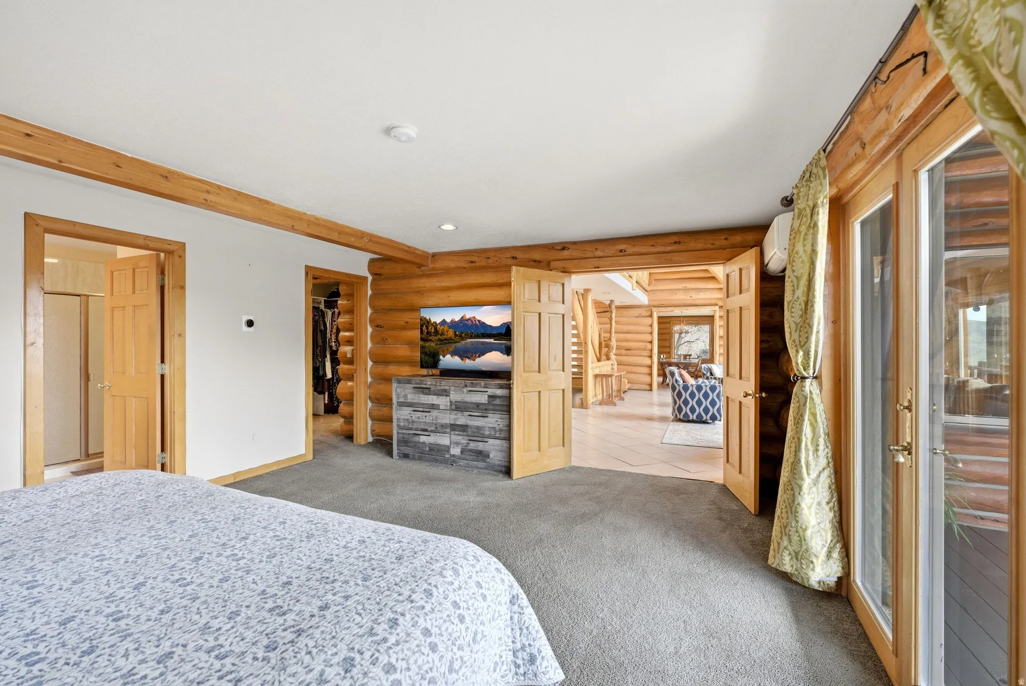 Carpeted bedroom with log walls, recessed lighting, and a spacious closet