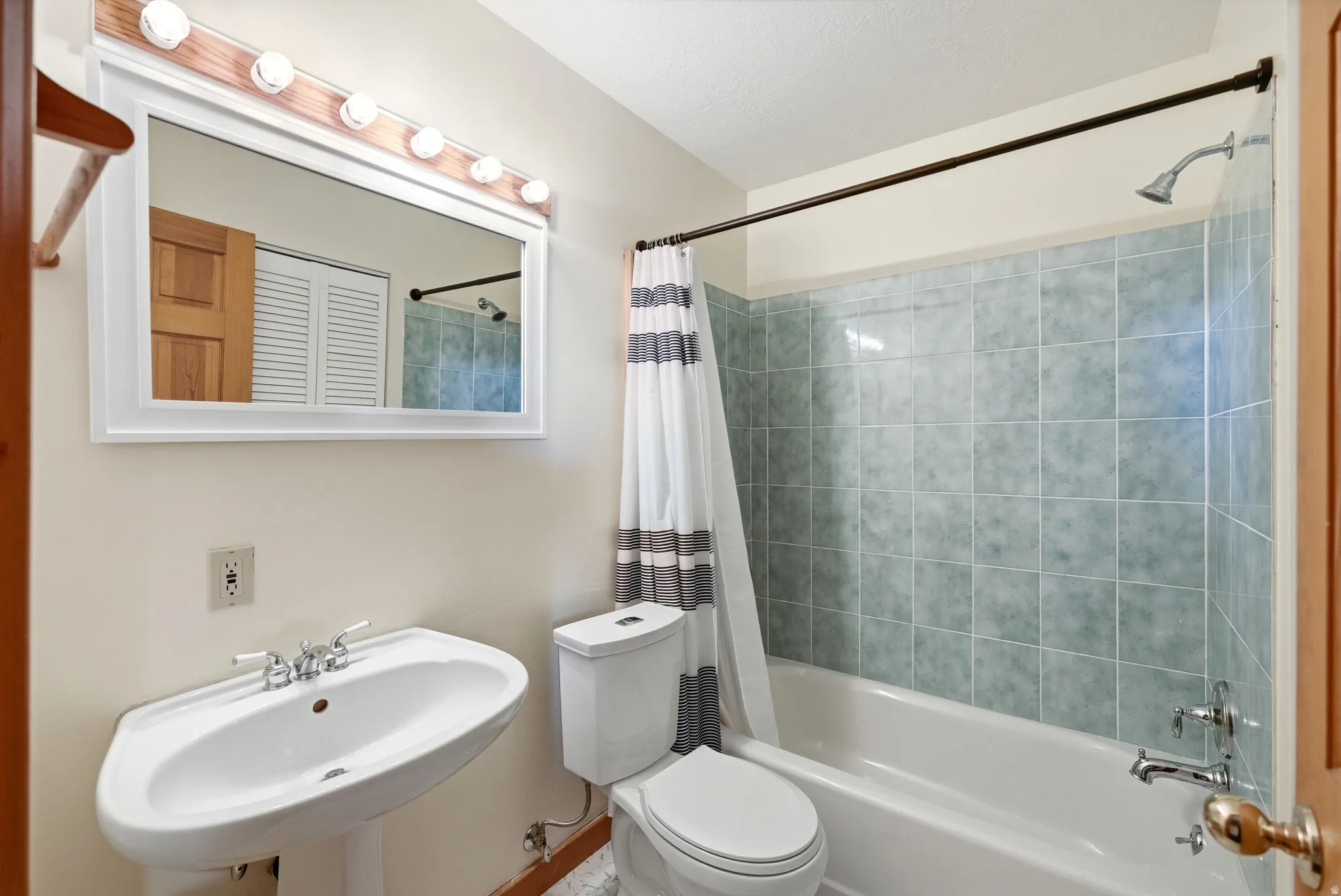 Full bath with toilet and shower / bathtub combination with curtain