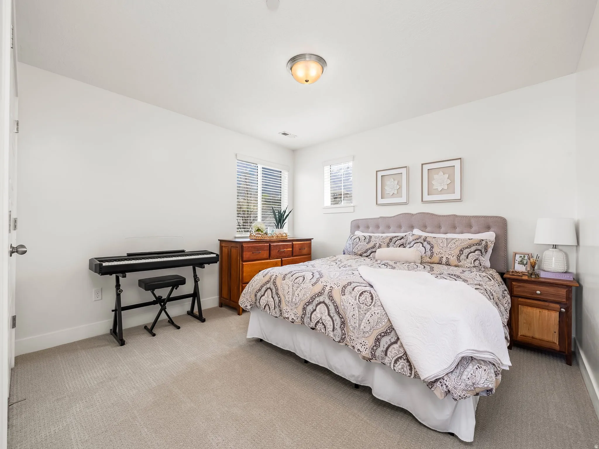 Bedroom featuring light carpet and baseboards