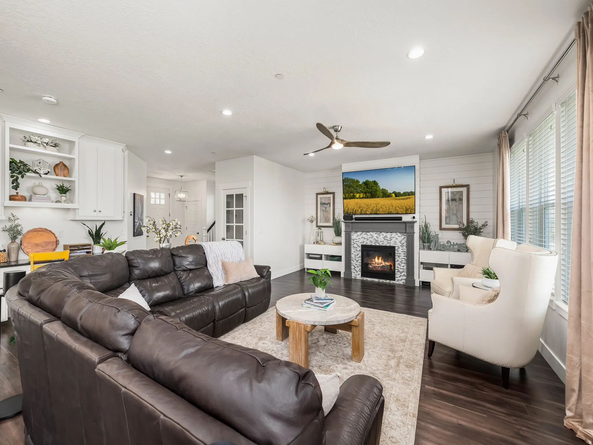 Living room featuring dark wood finished floors, a ceiling fan, a fireplace, and recessed lighting