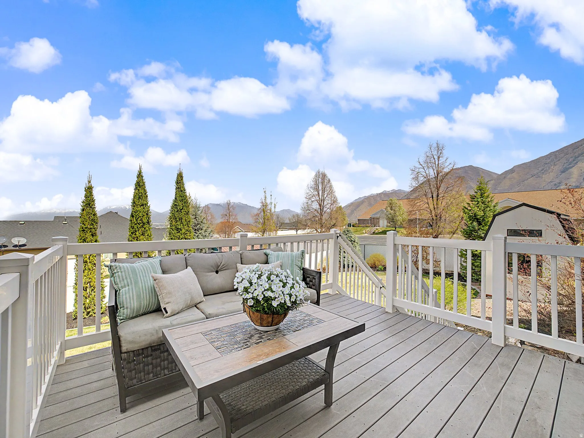 Deck featuring an outdoor living space, a mountain view, a storage unit, and a residential view