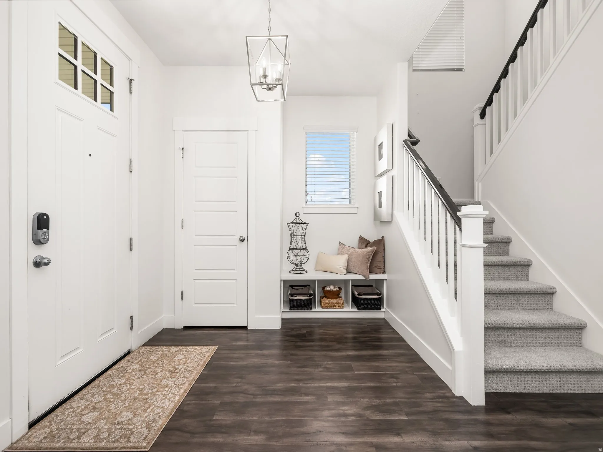 Entrance foyer featuring dark wood-style floors and hanging lights