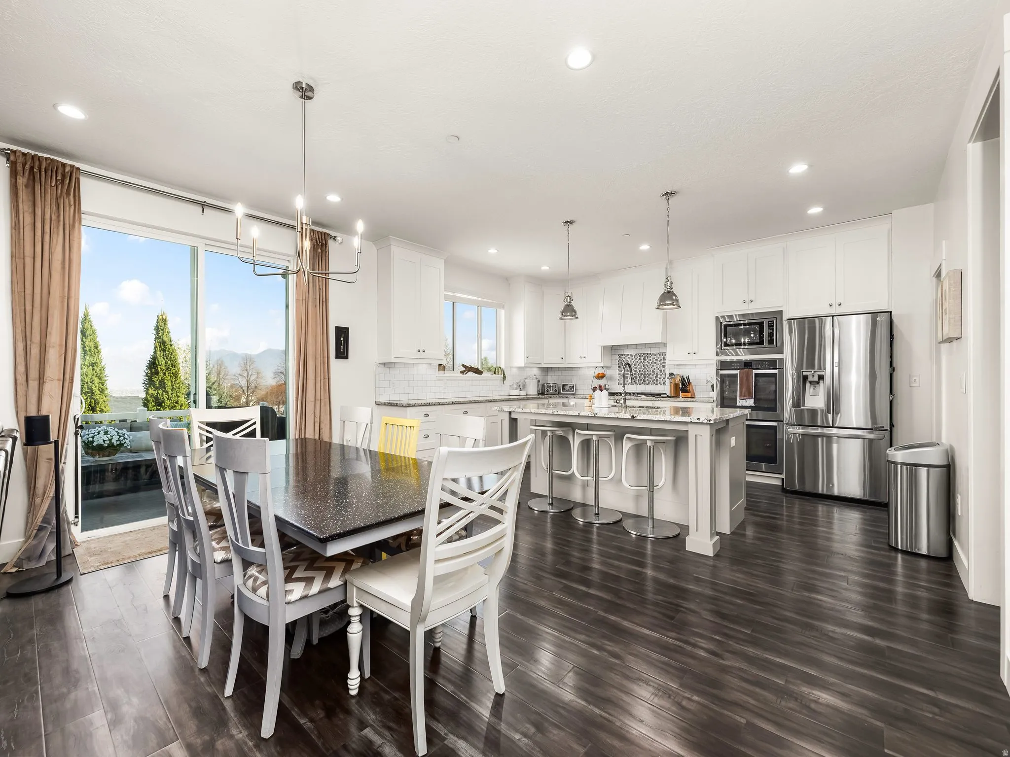 Dining space featuring hanging lights and dark wood-style floors