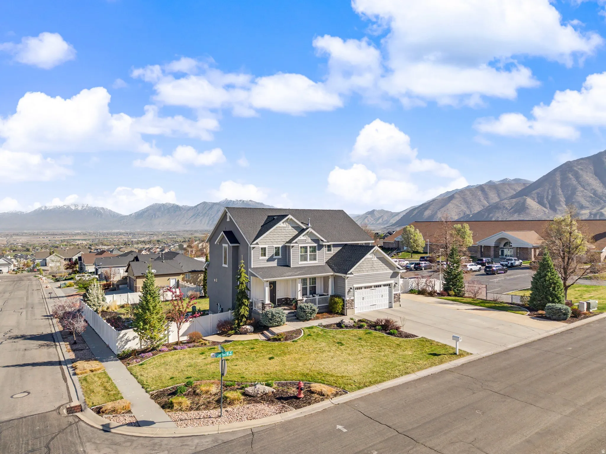View of front of property with a residential view, a mountain view, concrete driveway, and a garage