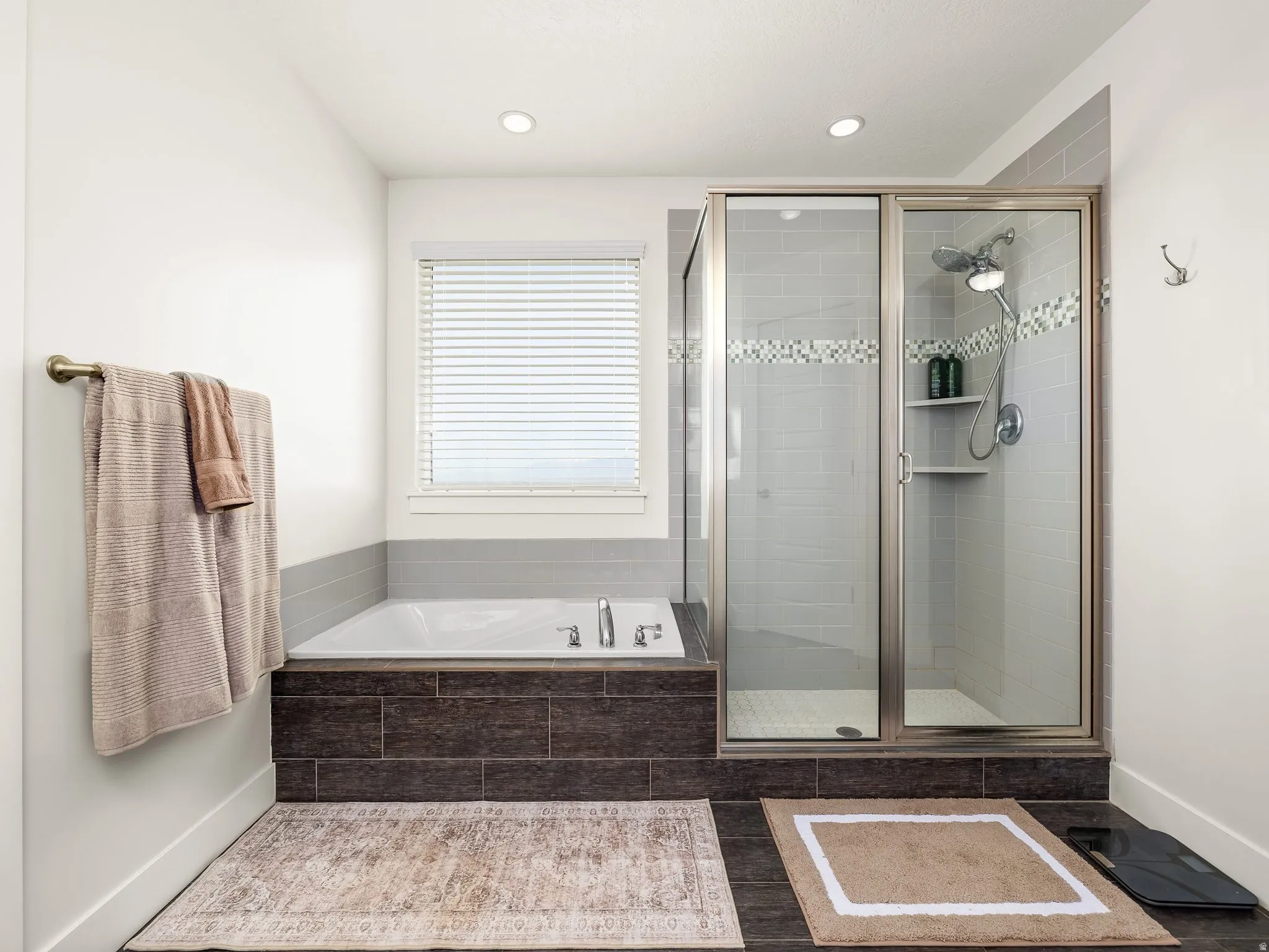 Bathroom with a stall shower, a bath, and recessed lighting