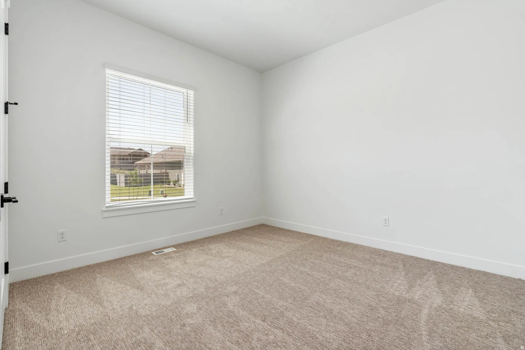 Spare room featuring carpet and baseboards