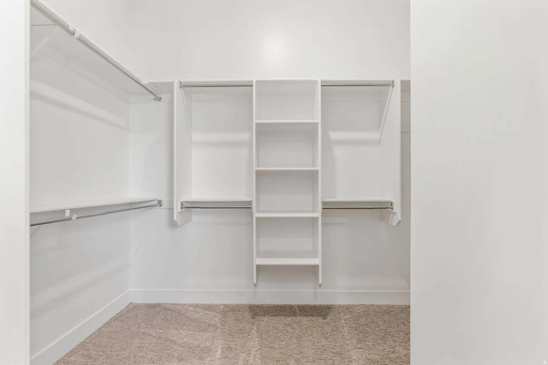 Walk in closet with light colored carpet
