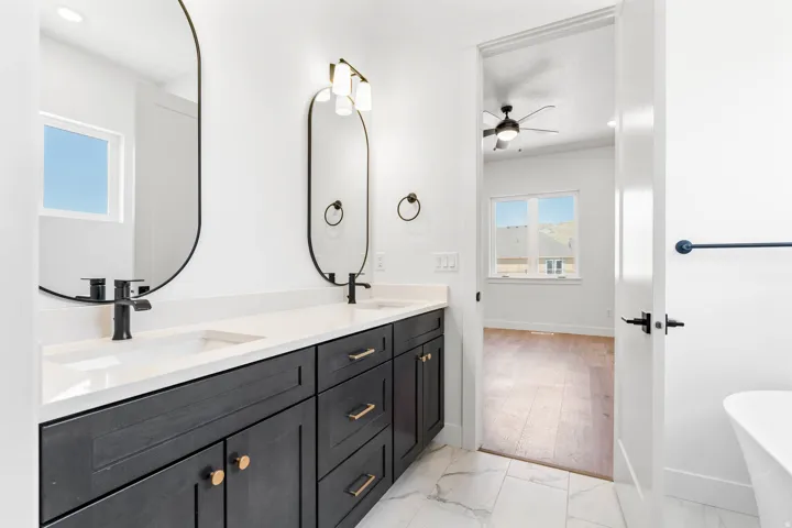 Bathroom with light marble finish floors, double vanity, a freestanding bath, ceiling fan, and recessed lighting