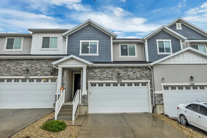 Craftsman house featuring stone siding, concrete driveway, board and batten siding, and an attached garage