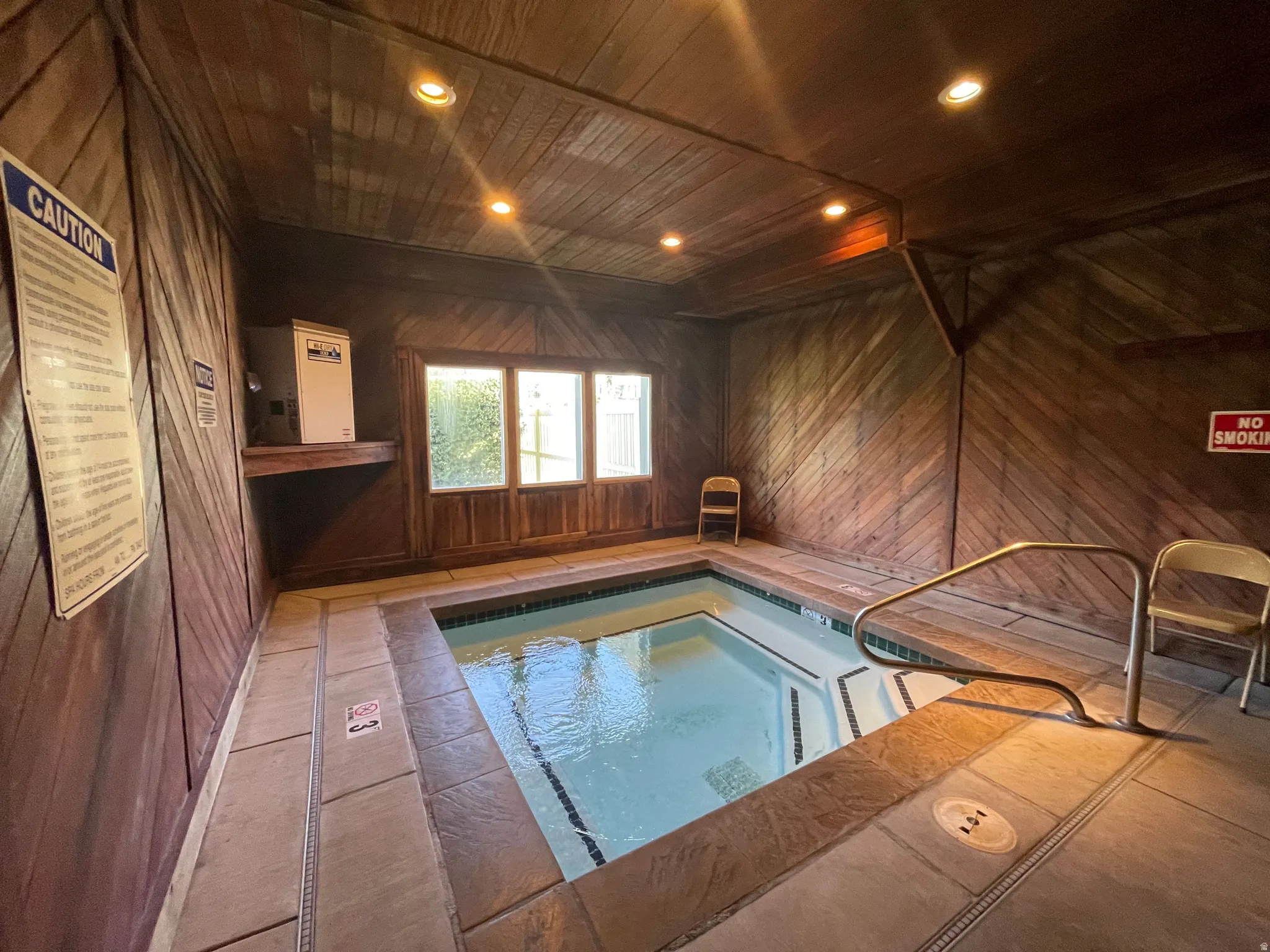 View of enclosed community hot tub with natural and recessed lighting