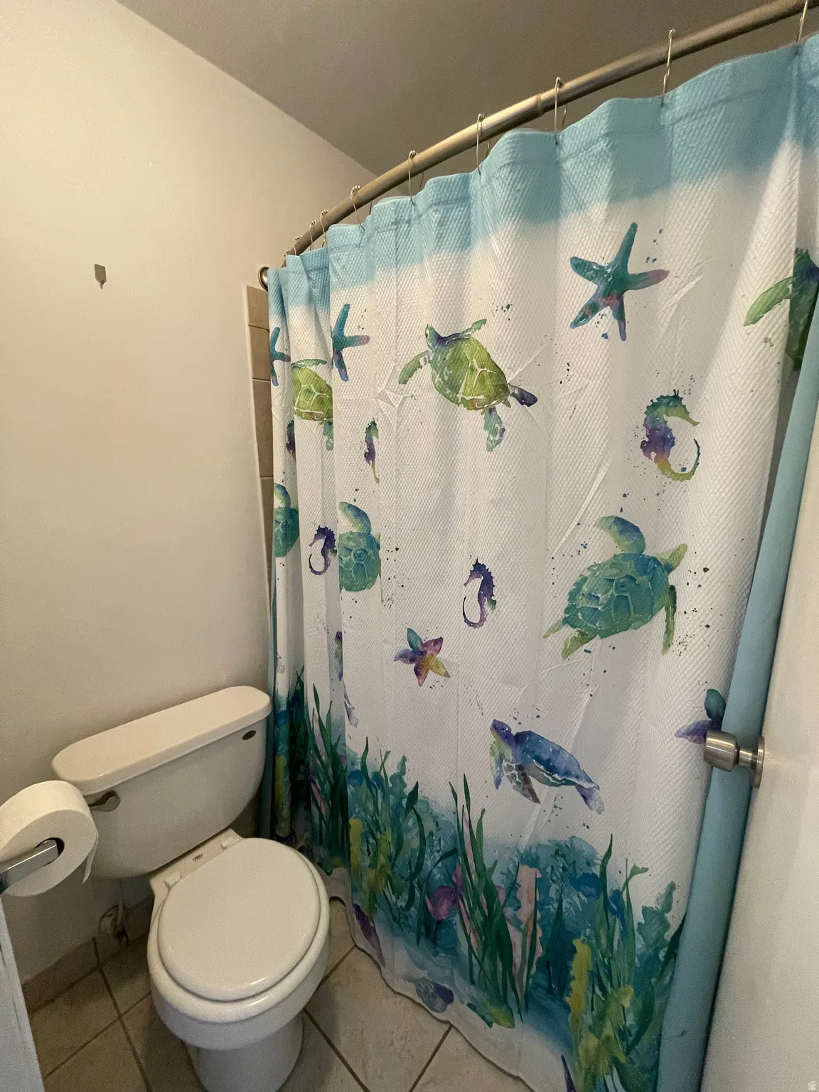 Full bath featuring light tile patterned flooring and curtained shower