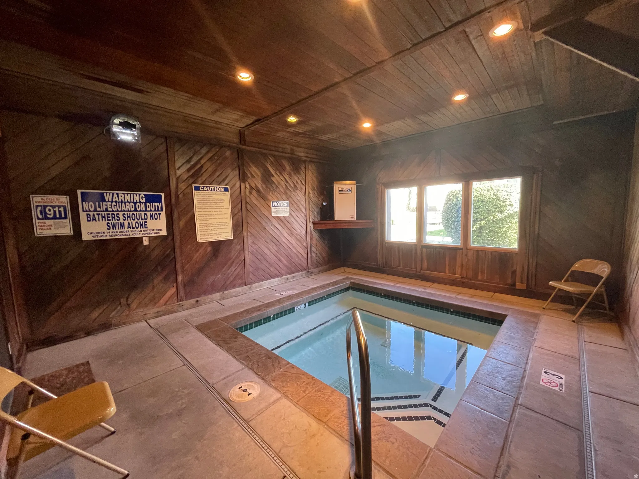 View of enclosed community hot tub with natural and recessed lighting