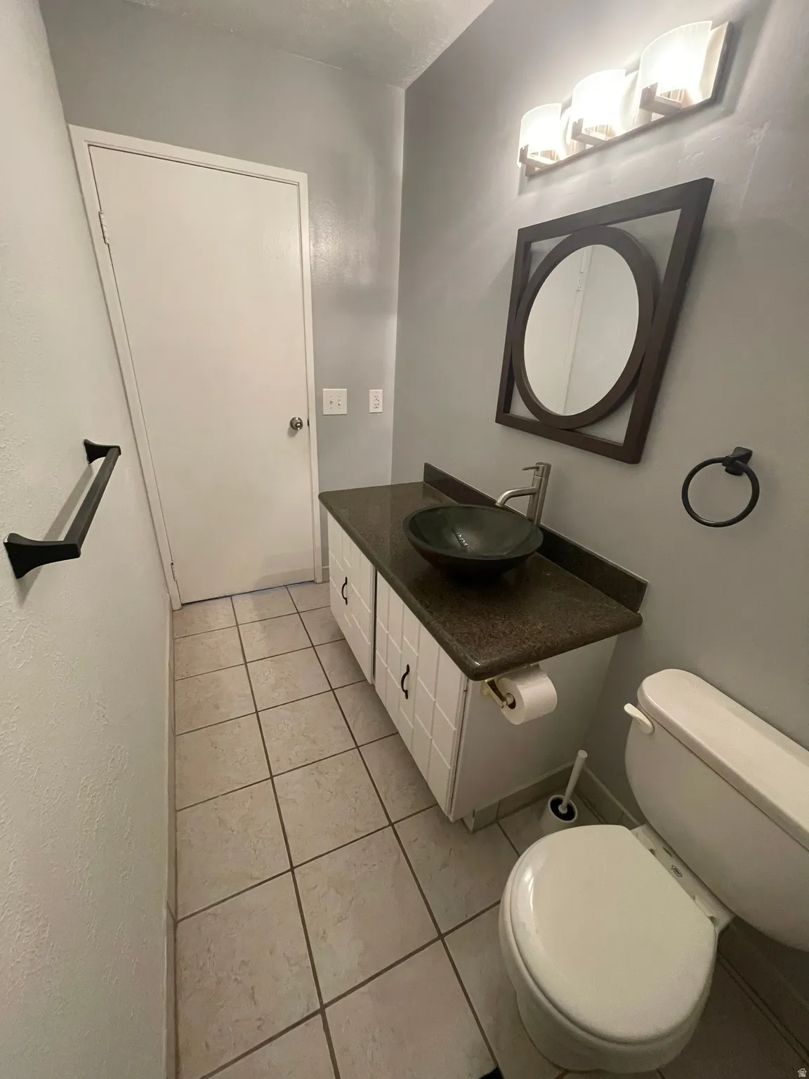 Hall bathroom featuring vanity and light tile patterned floors