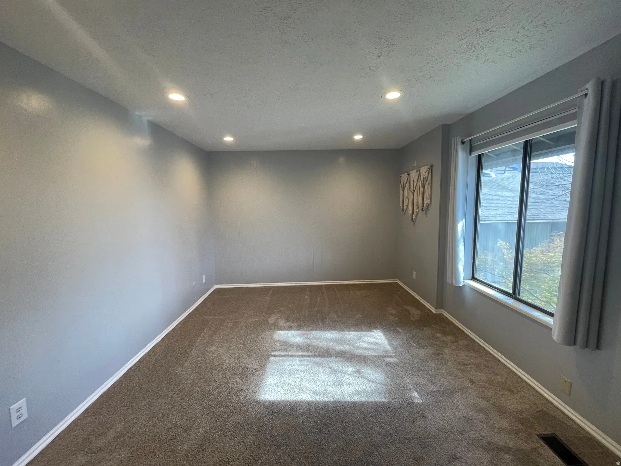 Spare second room with recessed lighting, dark colored carpet, and a textured ceiling