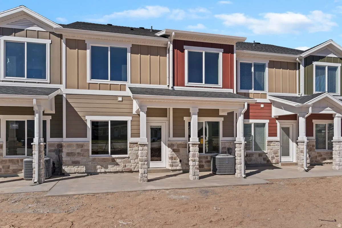 View of front of property featuring board and batten siding, stone siding, and roof with shingles