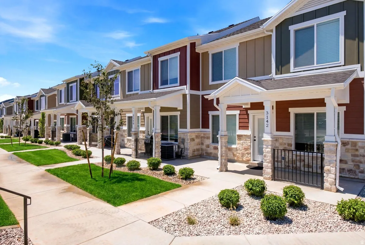 Contemporary townhome row featuring multi-toned siding exteriors with stone veneer accents