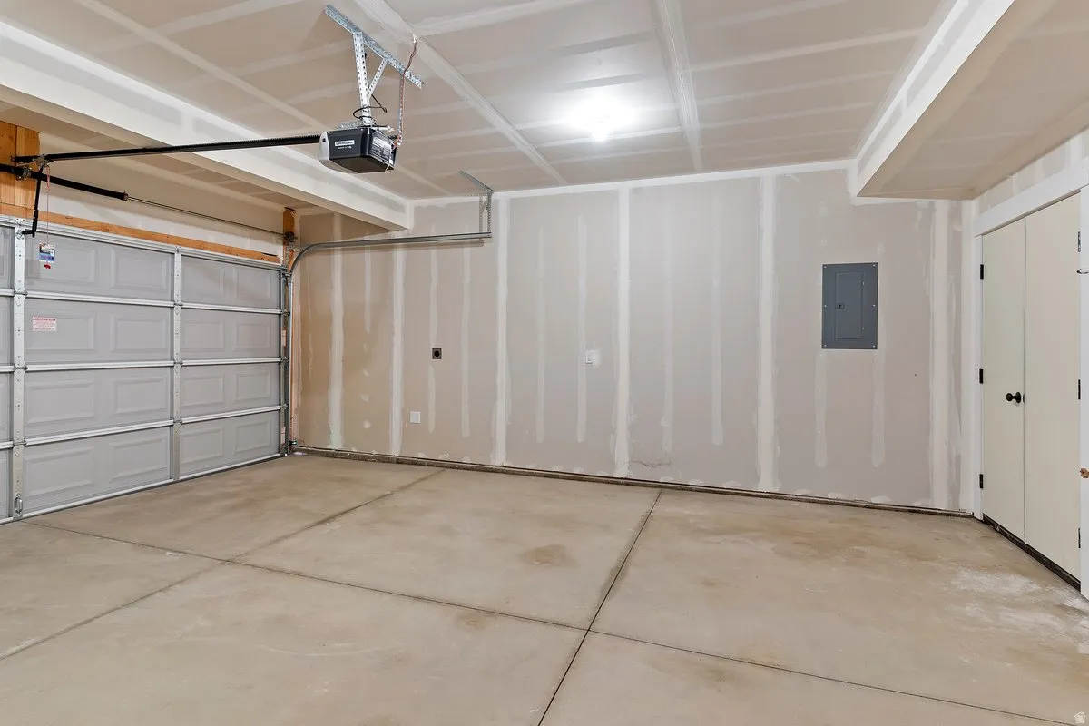 Garage featuring electric panel and a garage door opener