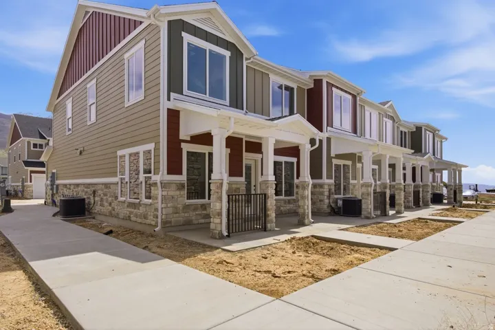 View of front of property featuring board and batten siding, stone siding, and a porch