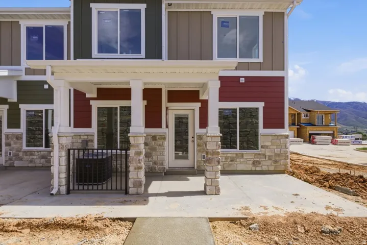 View of front of house featuring stone siding, covered porch, board and batten siding, and a mountain view