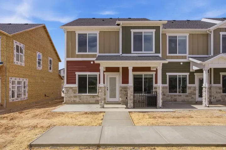 Craftsman-style house with board and batten siding, stone siding, a shingled roof, and a porch
