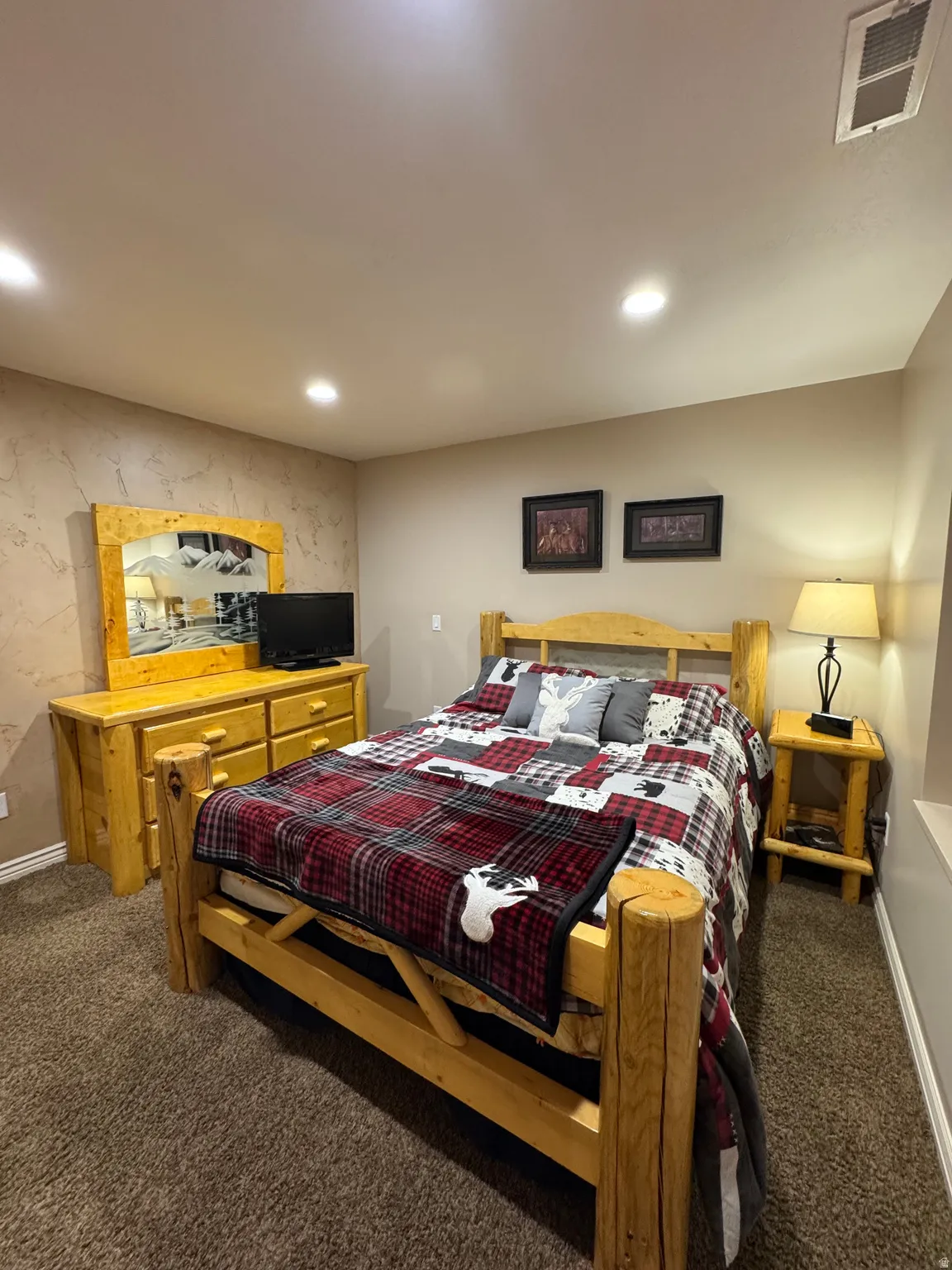Bedroom featuring dark carpet, recessed lighting, and an accent wall