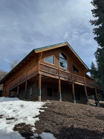 View of home's exterior with a deck and stone