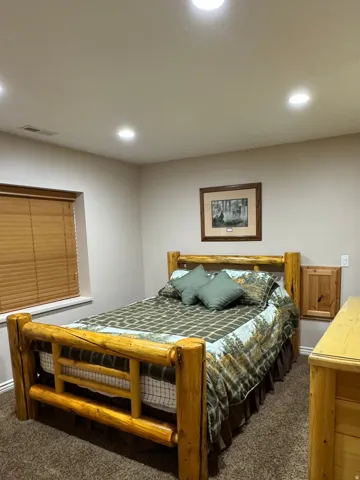 Bedroom with dark carpet and recessed lighting