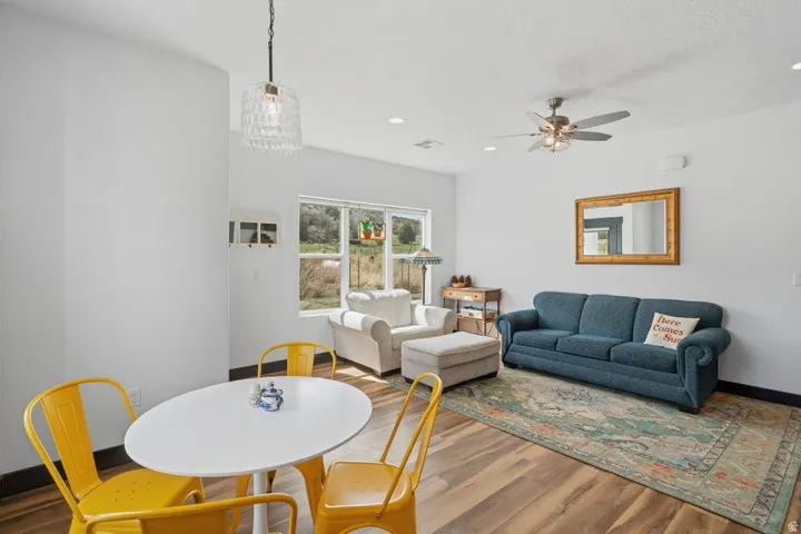 Dining room with wood finished floors, a ceiling fan, and recessed lighting