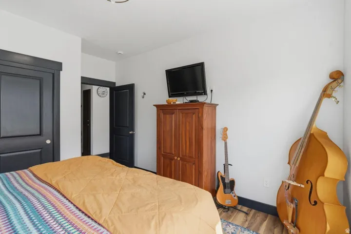 Bedroom with wood finished floors and a closet