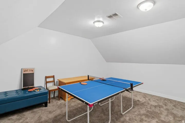 Recreation room featuring lofted ceiling and carpet floors