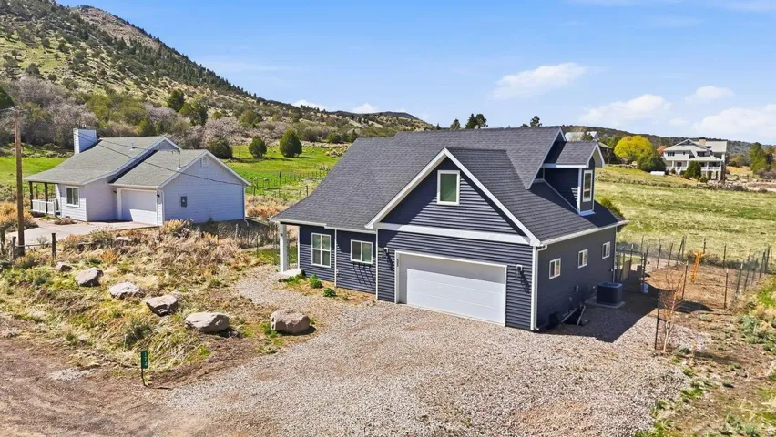 View of front of property featuring gravel driveway, roof with shingles, and a mountain view