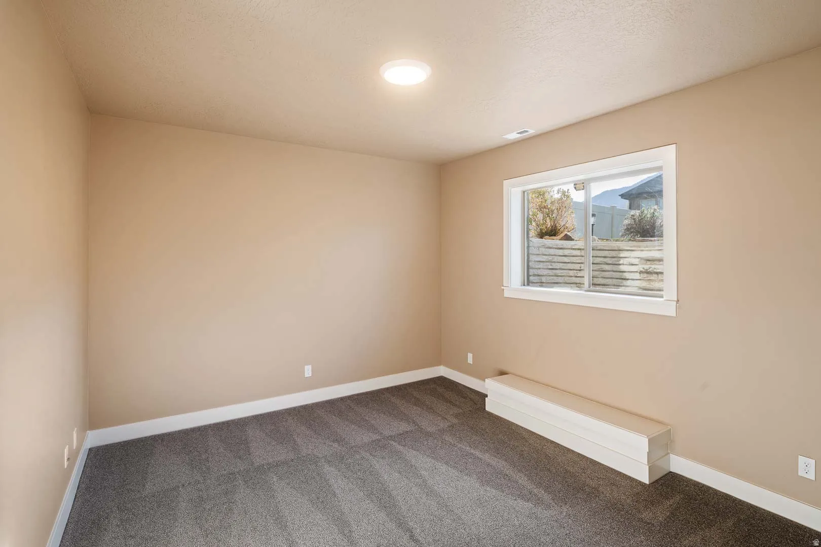 Carpeted empty room featuring baseboards