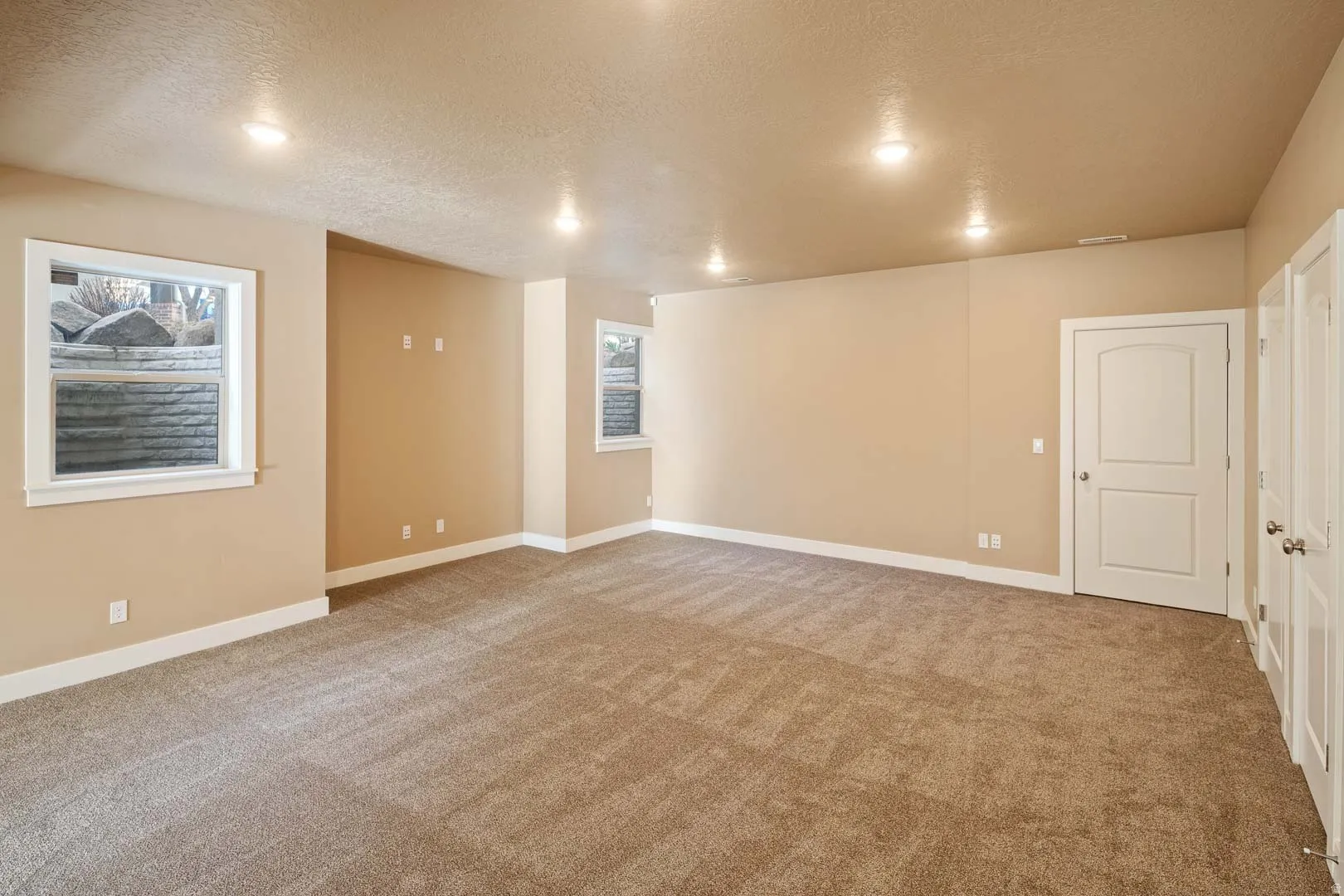 Unfurnished room featuring a textured ceiling and light carpet