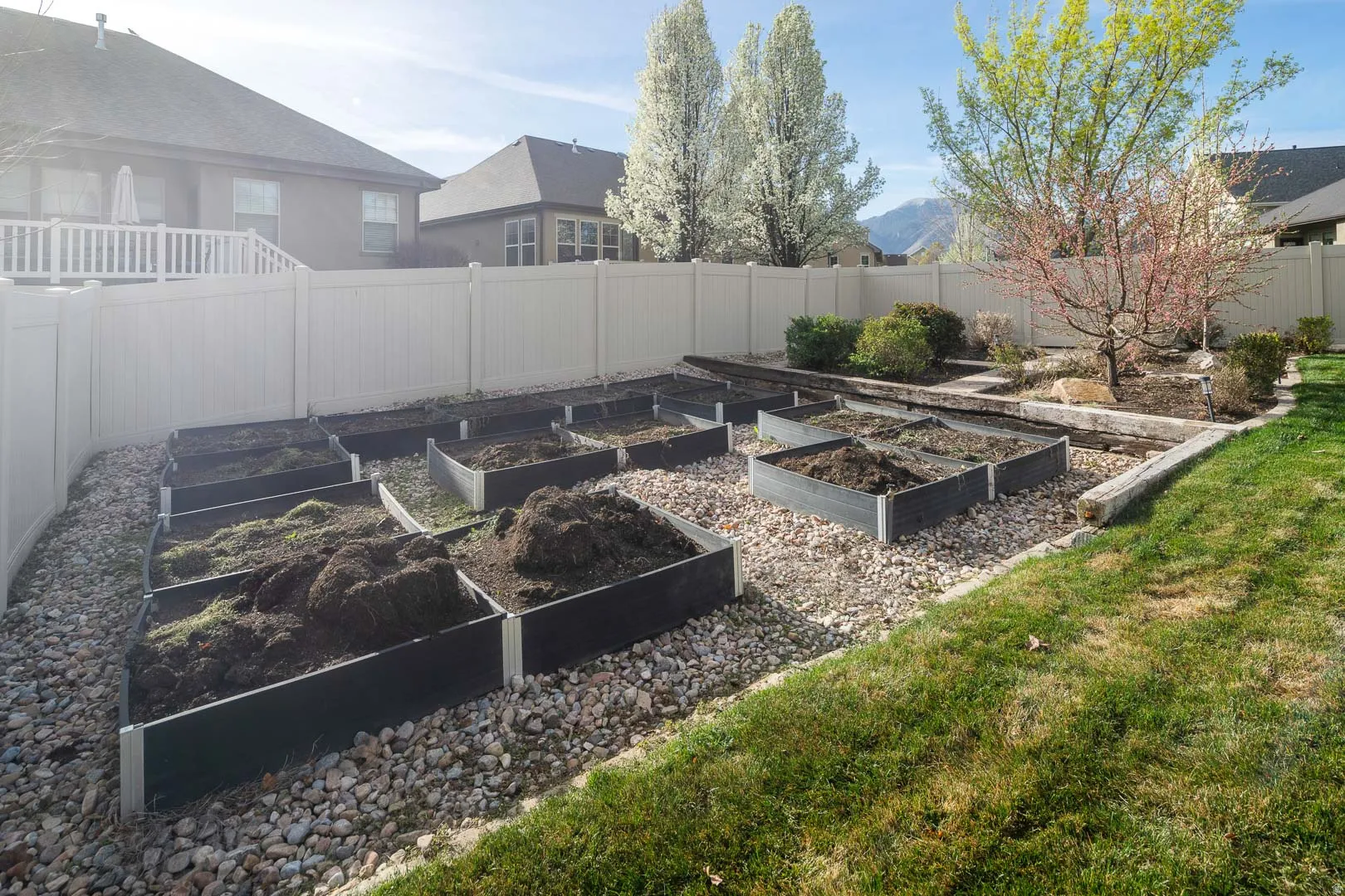 Fenced backyard featuring a vegetable garden and a mountain view