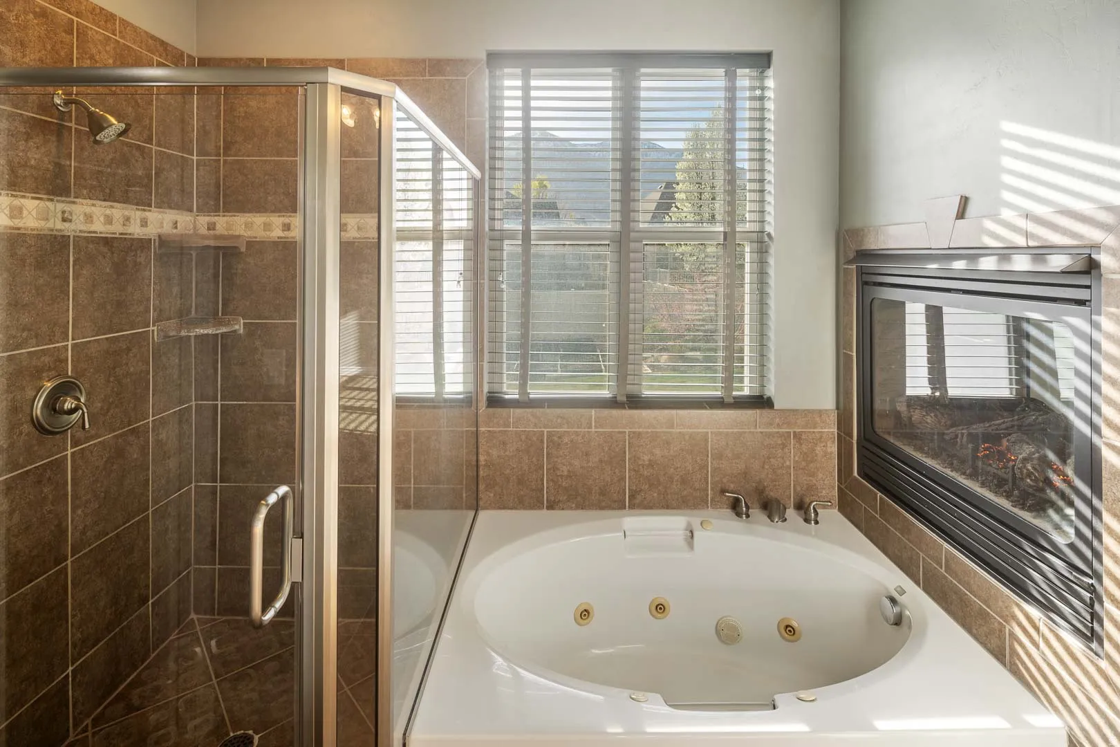 Full bath featuring a stall shower and a whirlpool tub