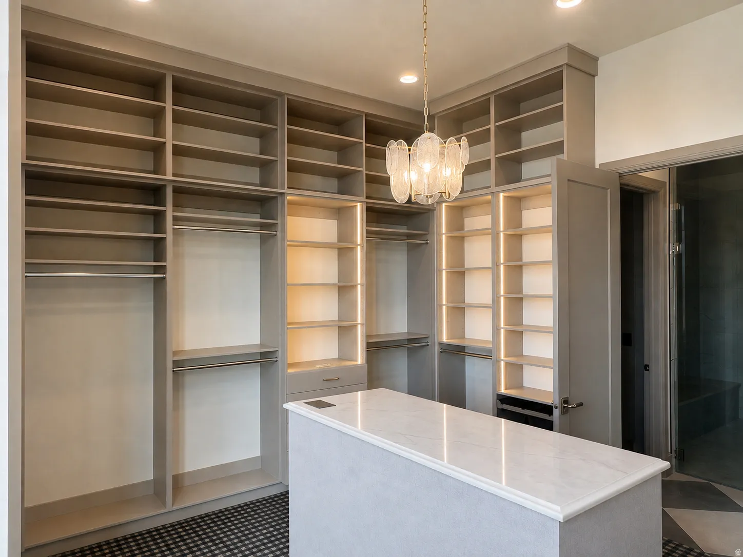 Custom built-in shelving, integrated closet rods, and illuminated display shelves