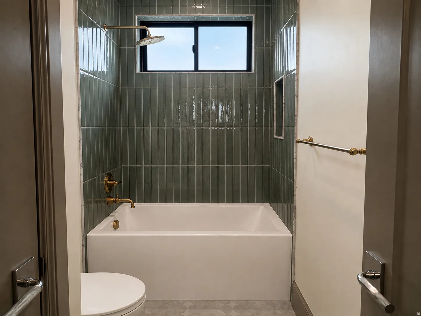 Bathtub with full-height green subway tile surround, integrated shower niche, and a window